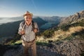 Old man just reaches the top of hill.Handsome senior man hiking, exploring