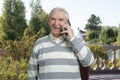 Happy old man talking on phone outdoor. Royalty Free Stock Photo