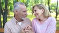 Happy old man and woman looking each other with love and holding hands, date Royalty Free Stock Photo