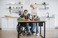 Happy old married man in wheelchair and wife prepare healthy salad. Royalty Free Stock Photo