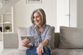 Happy old woman using digital tablet having virtual online meeting at home. Royalty Free Stock Photo