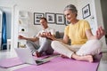 Happy senior couple having fun learning to meditate, watching online yoga class.