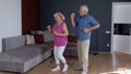 Happy old senior couple dancing having fun celebrating retirement anniversary in living room at home Royalty Free Stock Photo