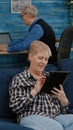 Happy old senior grandmother holding digital tablet browsing informations Royalty Free Stock Photo