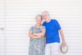 Happy old senior people caucasian couple standing and posing smiling with wooden white wall background - bright image with silver Royalty Free Stock Photo