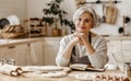 Happy old woman Granny cooks in kitchen kneads dough, bakes cookies