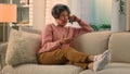 Happy old woman relaxing on cozy sofa talking on smartphone smiling senior grandma at comfy couch at home distant talk Royalty Free Stock Photo