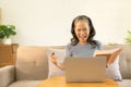 Happy old woman working on her laptop at home. Staying at home. Working from home. Royalty Free Stock Photo