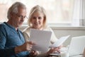 Happy older aged couple holding reading good news in document