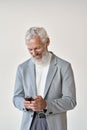 Happy old senior businessman using smartphone standing isolated on white. Royalty Free Stock Photo