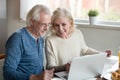 Happy older family couple talking using laptop having breakfast Royalty Free Stock Photo