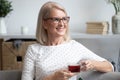 Happy older lady relaxing alone with cup of tea. Royalty Free Stock Photo