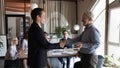 Happy older male team leader giving handshake to excited employee Royalty Free Stock Photo