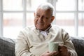 Happy older man relaxing on sofa with cup of coffee. Royalty Free Stock Photo