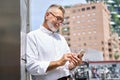 Happy old professional business man holding mobile phone using cell in city. Royalty Free Stock Photo