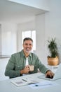 Happy older mature man drinking coffee using laptop at home table. Portrait. Royalty Free Stock Photo