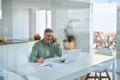 Happy older mature man talking on phone using laptop at home. Royalty Free Stock Photo