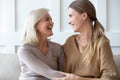 Happy older mother and adult daughter hugging, having fun together