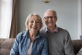 Happy older retired husband and wife sitting on home couch Royalty Free Stock Photo