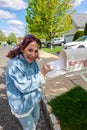 Happy older senior citizen woman smiles as she removes a blank white envelope from a white mailbox Royalty Free Stock Photo