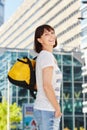 Happy older woman carrying duffel bag in city