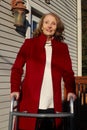 Happy Older Woman in Red Coat Using a Walker