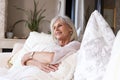 Happy older woman sitting on couch relaxed Royalty Free Stock Photo