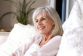 Happy older woman sitting on couch relaxed and smiling Royalty Free Stock Photo