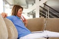 Happy older woman sitting on sofa looking laptop Royalty Free Stock Photo