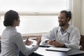 Happy optimistic young doctor listening to patient at appointment Royalty Free Stock Photo