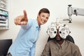 Happy optometrist doing eye test on a patient, examining vision and doing optical exercise at an optometry checkup Royalty Free Stock Photo