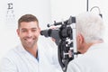 Happy optometrist examining senior patients eye