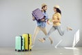 Happy overjoyed couple jumping with travel accessory funny studio portrait