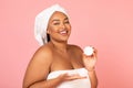 Happy Oversized African American Woman Showing Moisturizer Jar, Pink Background