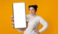 Happy oversized lady showing smartphone with big empty screen, demonstrating mobile app or website design