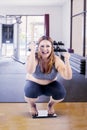 Overweight woman squat down on the weight scales