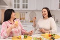 Happy overweight women having healthy meal together at table in kitchen Royalty Free Stock Photo