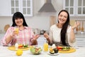 Happy overweight women having healthy meal together at table in kitchen Royalty Free Stock Photo