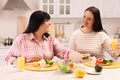 Happy overweight women having healthy meal together at table in kitchen Royalty Free Stock Photo