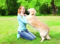 Happy owner woman is training her Golden Retriever dog on the grass in summer park Royalty Free Stock Photo