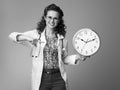 Happy paediatrician doctor pointing at clock on