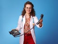 Happy paediatrician doctor with phone on blue