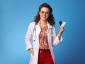 Happy paediatrist woman showing pills in blister pack on blue Royalty Free Stock Photo