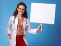 Happy paediatrist woman showing placard on blue
