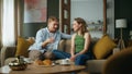 Happy pair chatting having breakfast at home. Emotional man telling funny story Royalty Free Stock Photo