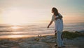 Happy pair playing dog sunset ocean. Loving teenagers embracing at sandy beach Royalty Free Stock Photo