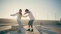 Happy pair riding skate boards sunny stadium. Carefree couple enjoying summer Royalty Free Stock Photo