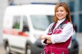 Happy paramedic with phonendoscope at emergency car background Royalty Free Stock Photo