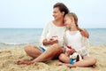 happy parent and child drinking tea on the beach