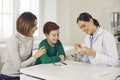 Smiling pediatric dentist or oral hygienist teaching patients to brush teeth properly